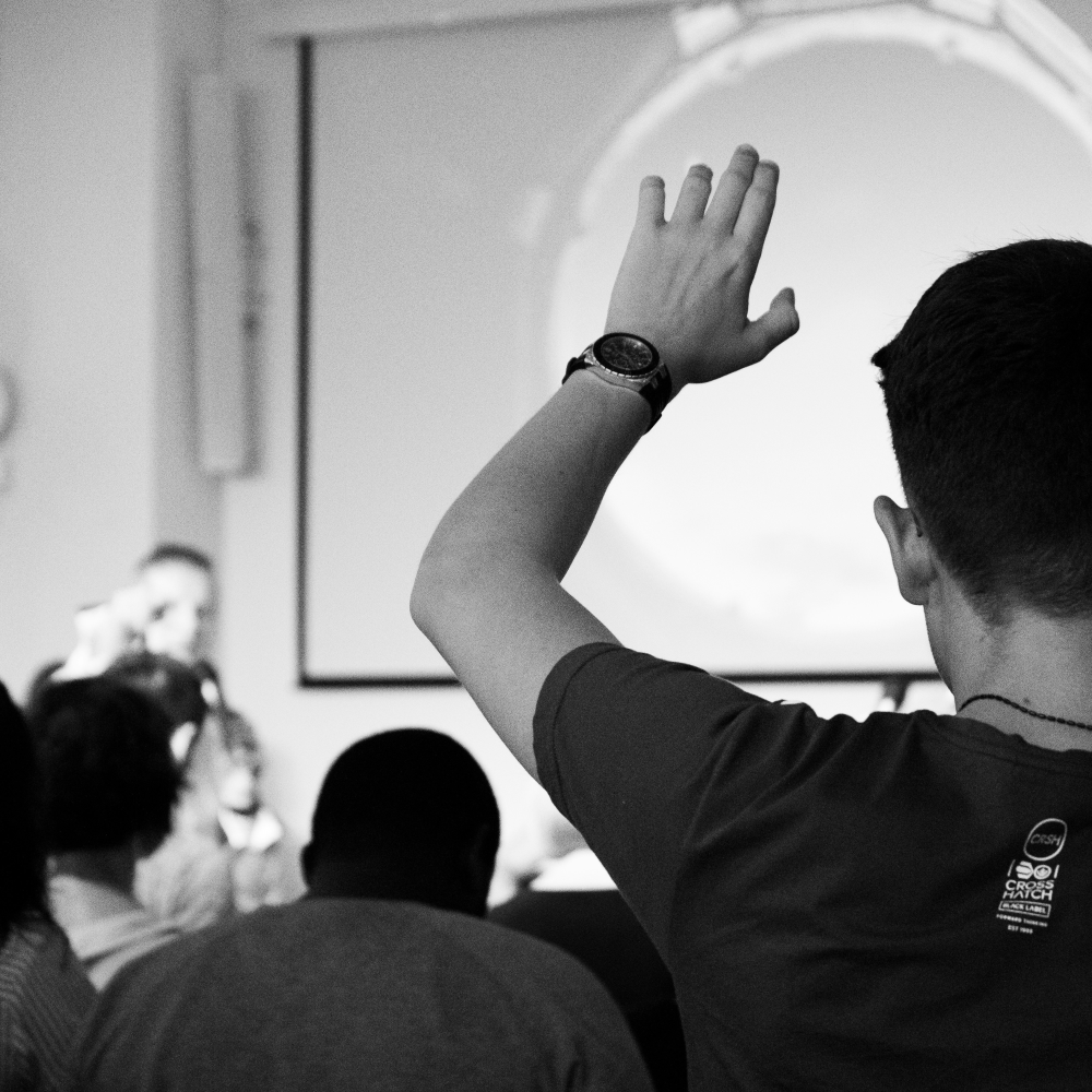 A student raising their hand to ask a question.