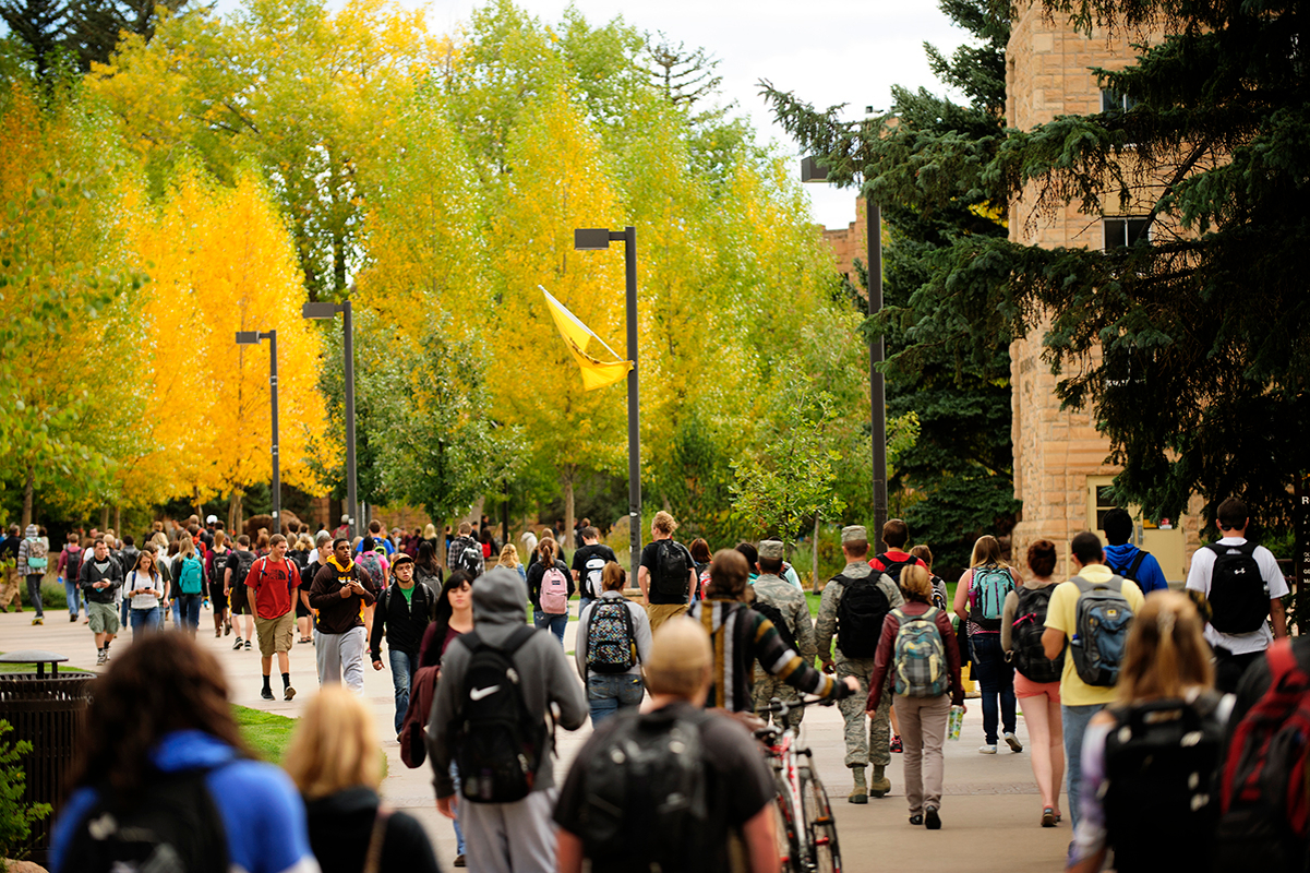 Students walking on a sidewalk in Prexy's Pasture on the University of Wyoming campus.