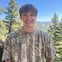 Zach Friel outdoors with mountains in the background