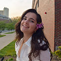 Madison Rhuman on a campus smiling with flowers in her hair