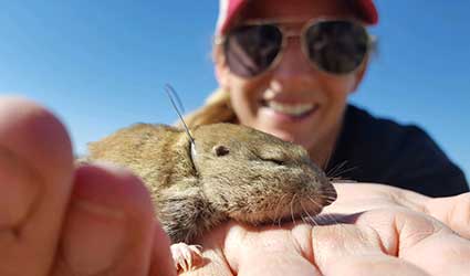 smiling student holding small rodent