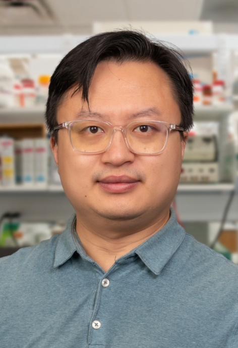 Li Li stands in front of a shelf of lab supplies.