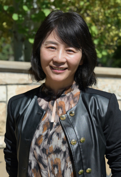 Yun Li stands in front of the UW sign.