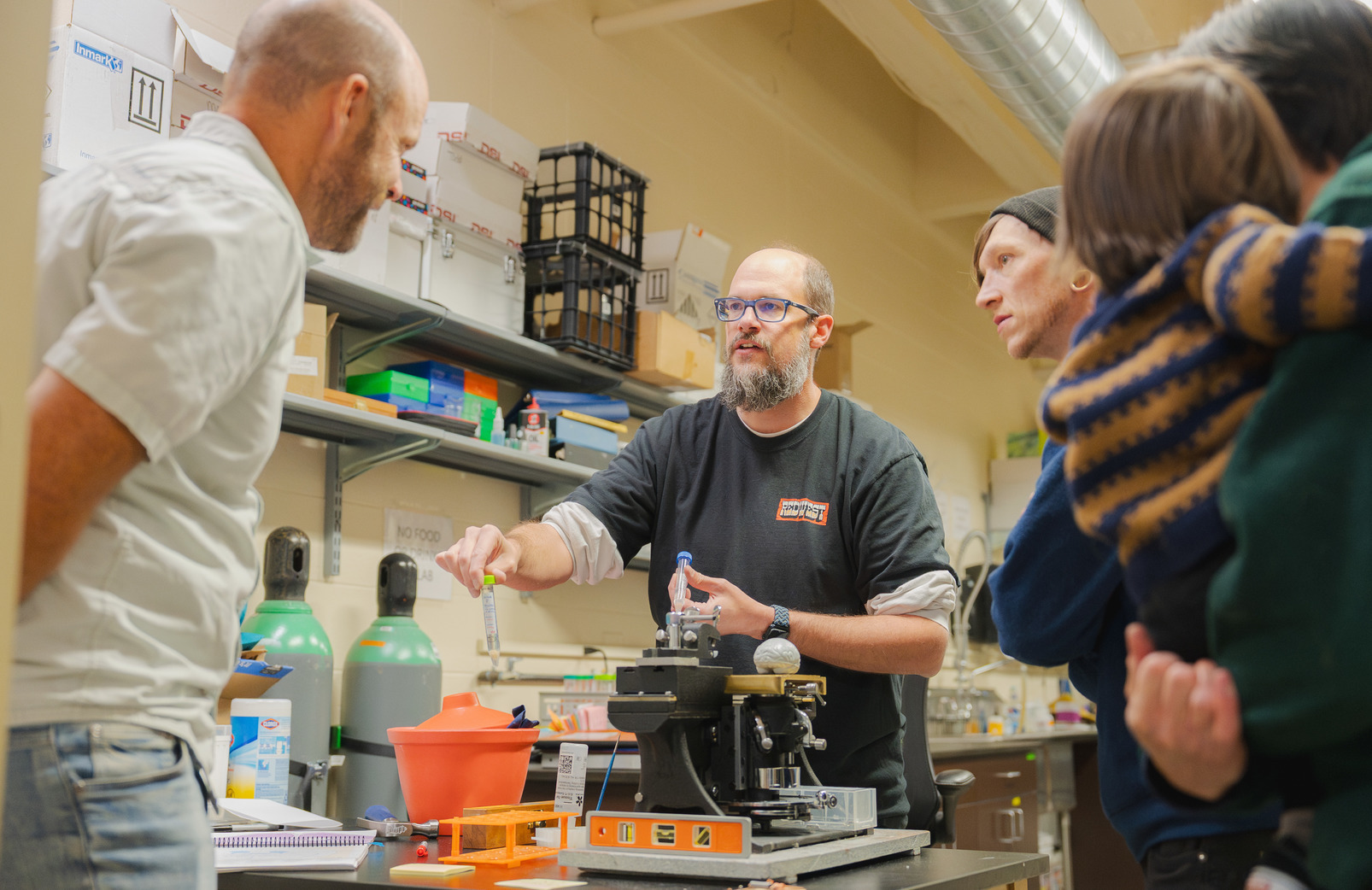 A professor showcases research tubes in his lab.