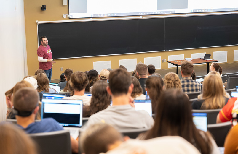 Dr. Wilford stands in front of a whiteboard teaching LIFE 1010.