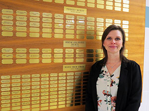 woman standing beside wall of tiny plaques