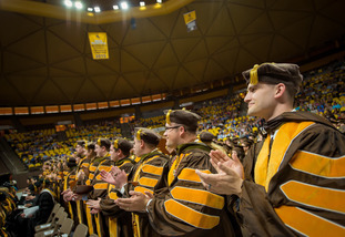 UW graduates clapping at ceremony